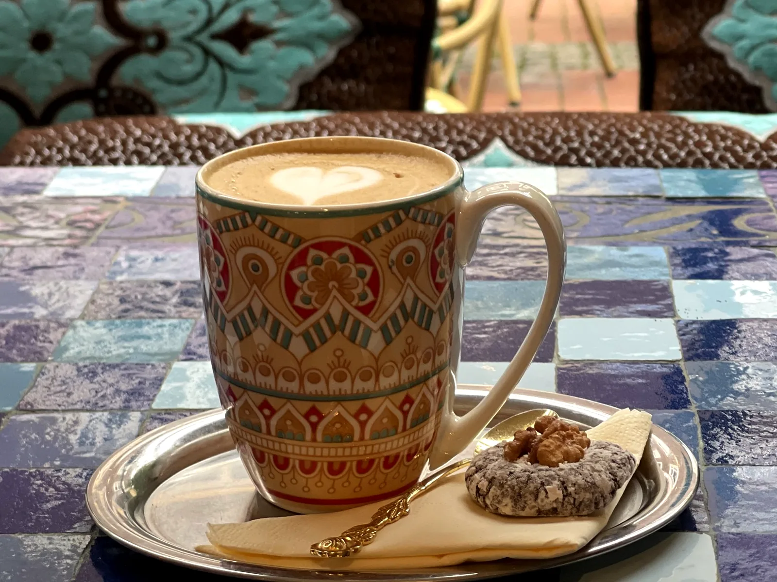 Milchkaffee im marokkanischen Becher mit Walnuss-Gebäck auf einem Silbertablett