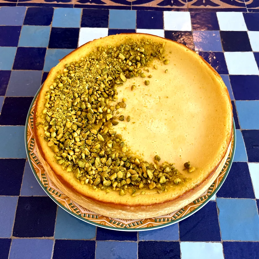 Pistazien-Cheesecake auf einem blauen Mosaiktisch